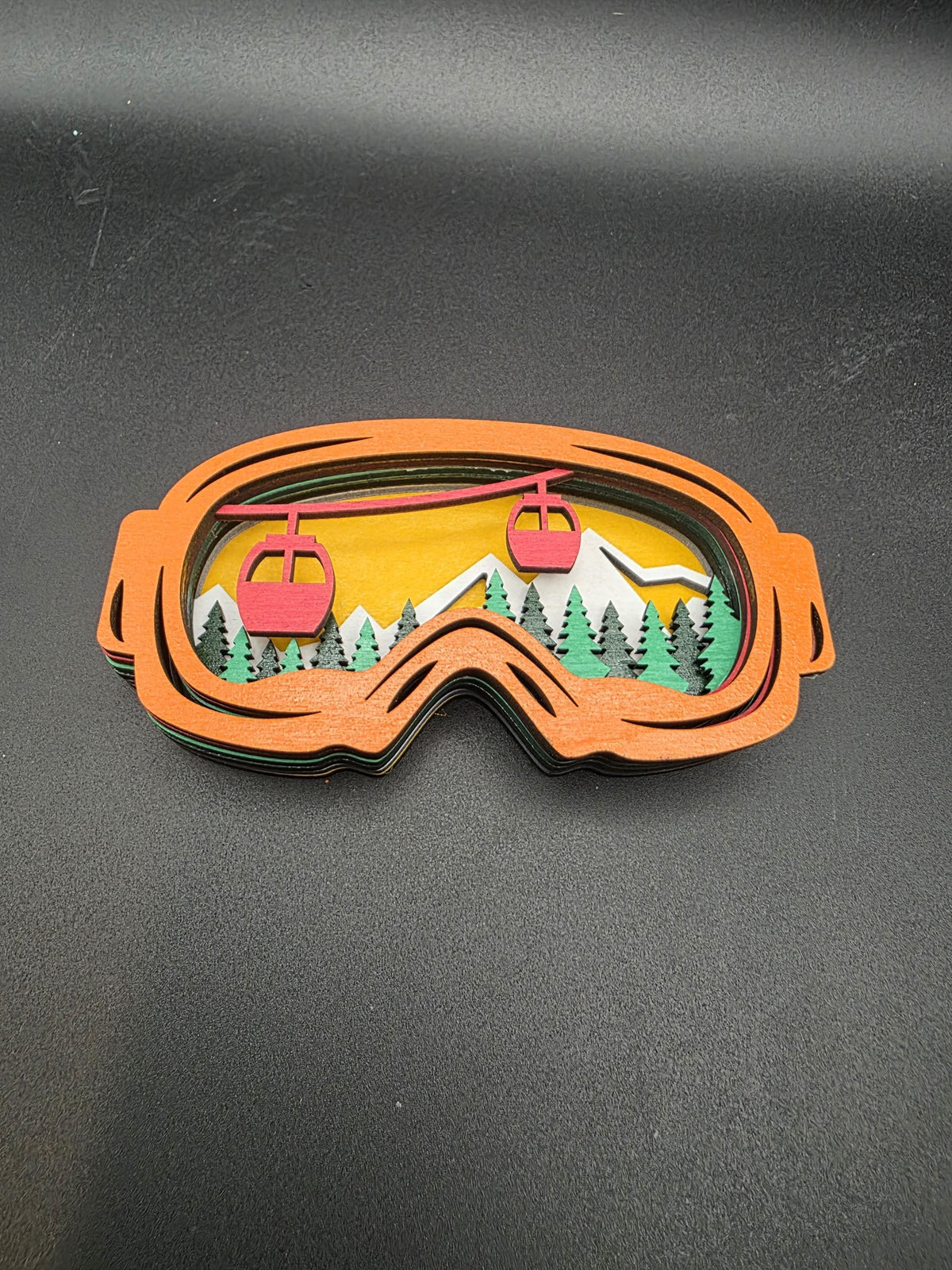 Orange-framed 3D wood ski lift ornament with red chairs and mountains