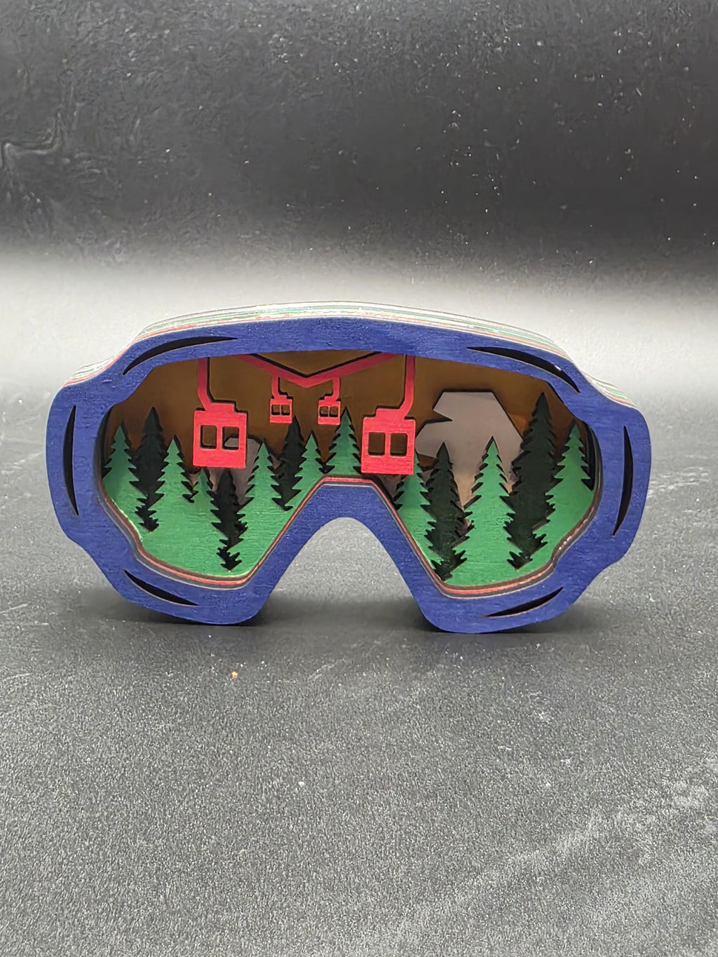 Blue-framed ski lift ornament with red chairlift over green pines