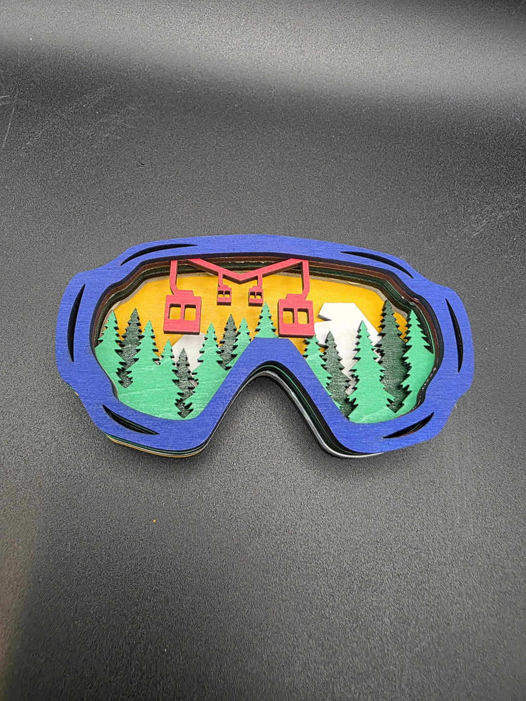 Blue-framed ski lift wall art piece, angled view showing the stacked wood layers