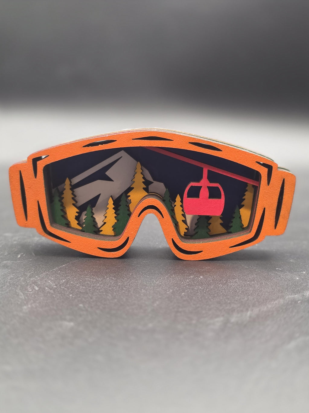 Orange-framed ski lift wall art piece with gray mountain peaks and a red gondola