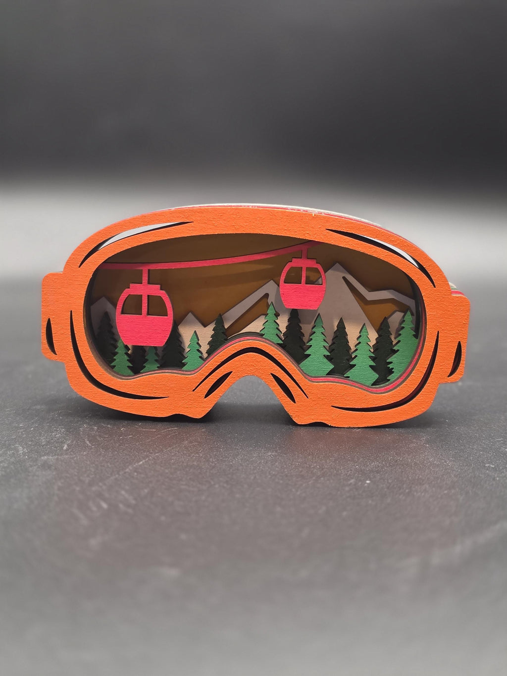 Orange-framed ski lift wall art piece with two red gondolas and pine trees