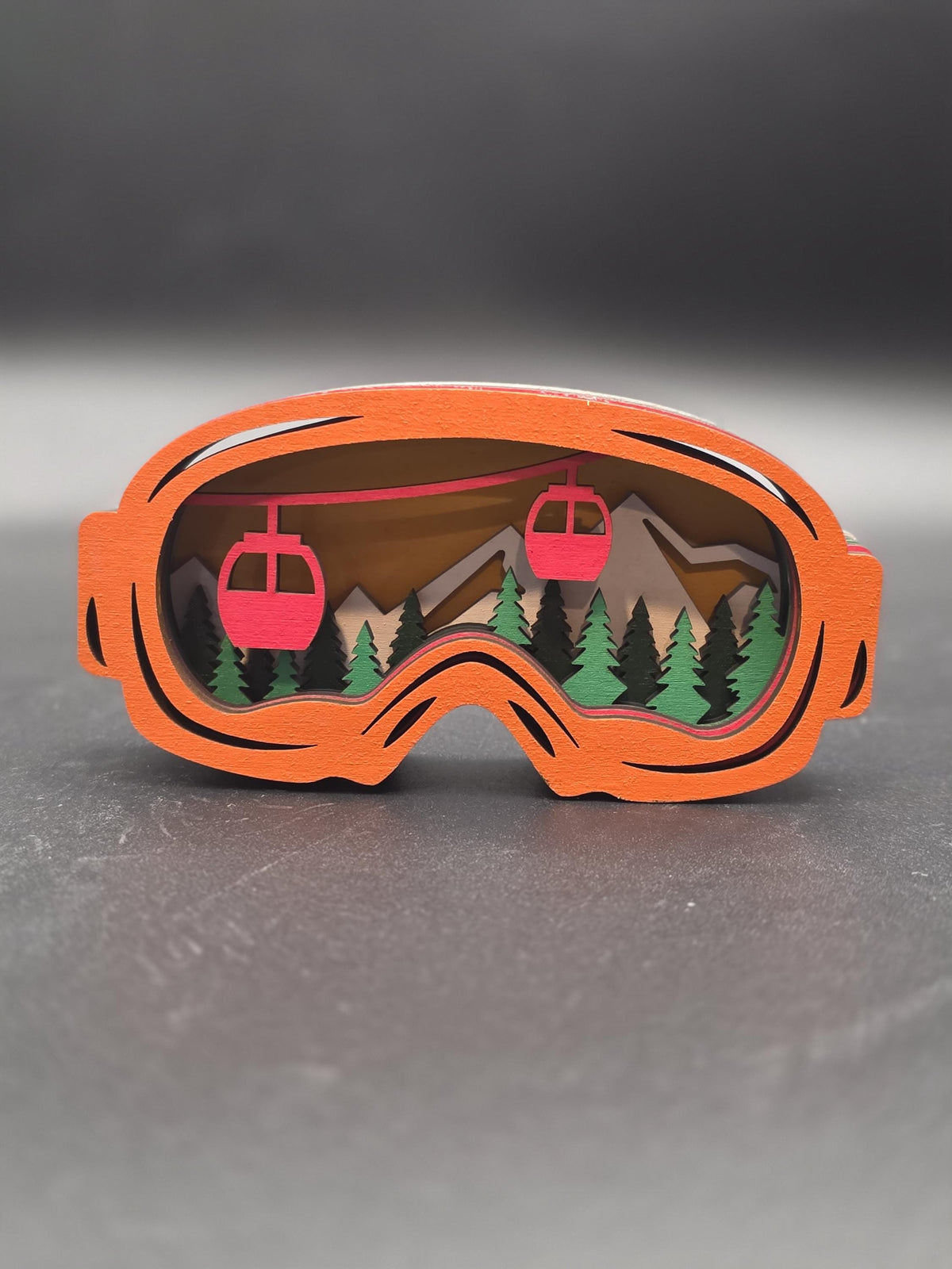Orange-framed ski lift wall art piece with two red gondolas and pine trees
