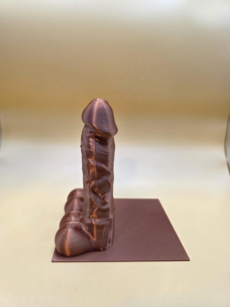 Single copper Balls Deep penis bookend, side view
