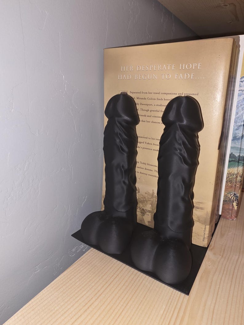 Black Balls Deep penis bookend pair on a base plate, angled view
