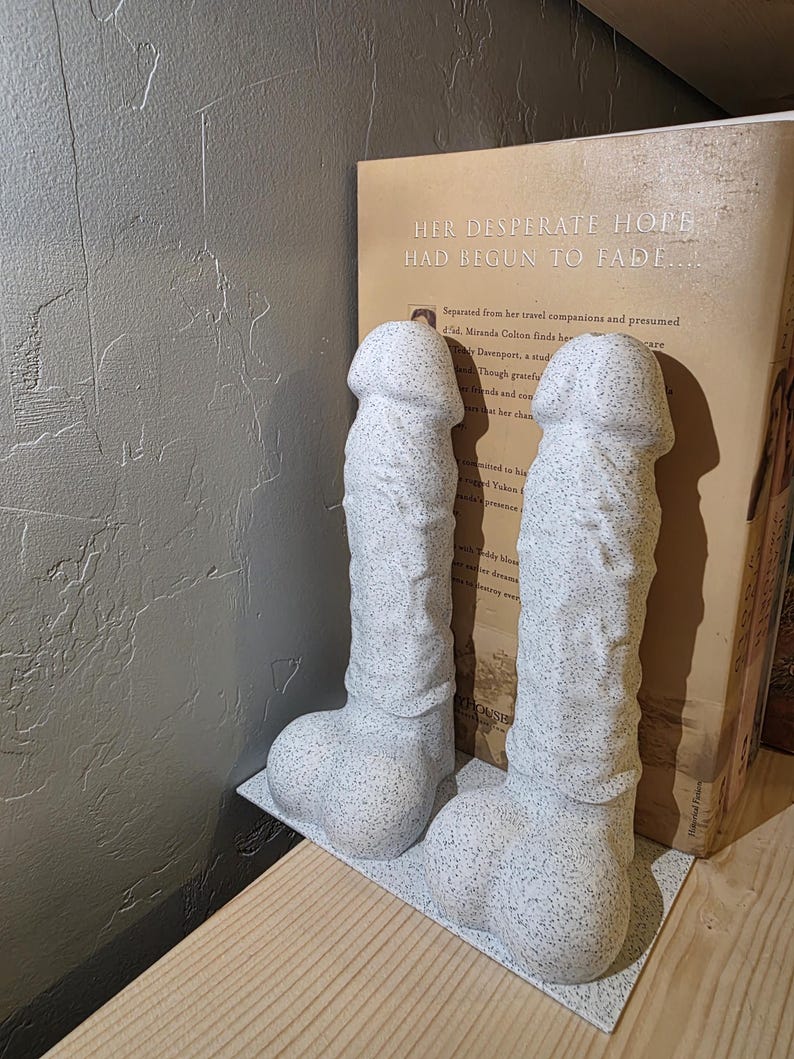 White Balls Deep penis bookends holding a hardcover book