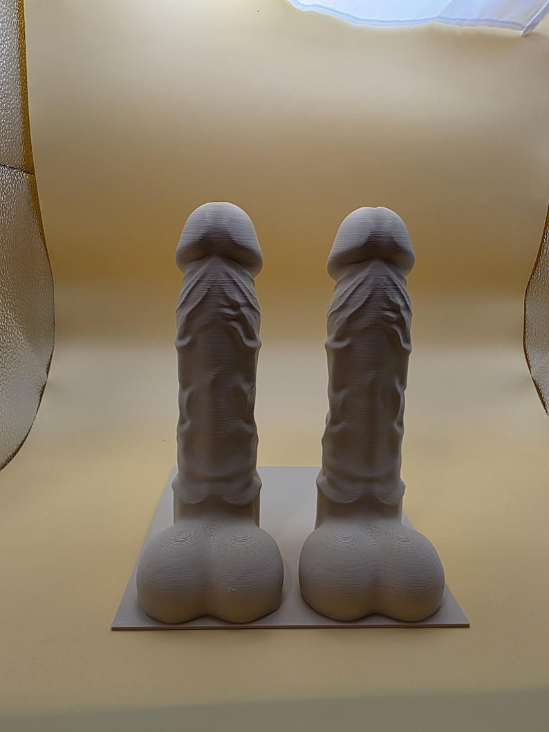 Gray-brown Balls Deep penis bookend pair on a base plate, front view