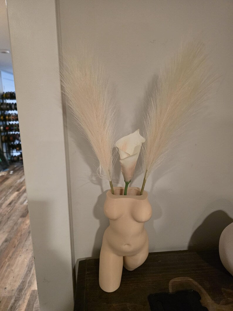 Beige Confident Curves planter with pampas grass on a floor display