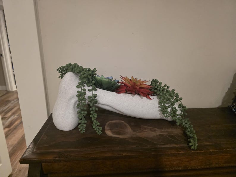 Oversized NSFW planter with trailing greenery
