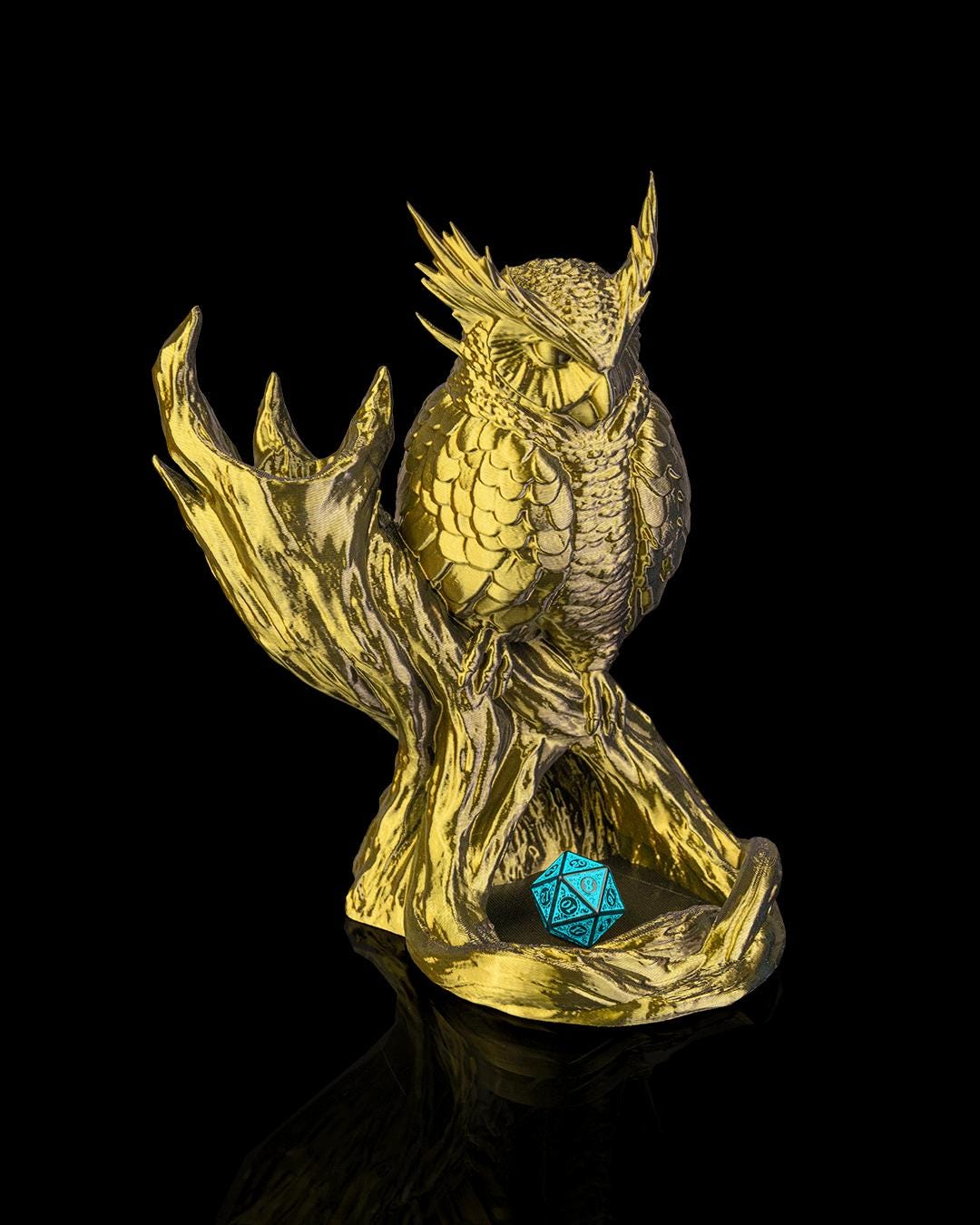 The Omen Owl dice tower in gold with a teal d20 in the tray