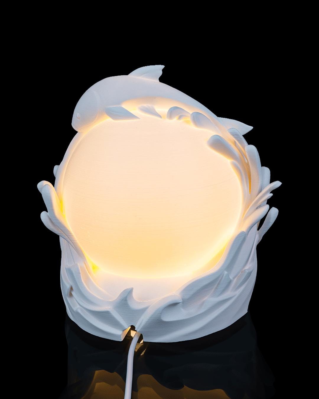 Twin fish sphere lamp lit, side view with fish curling around the sphere