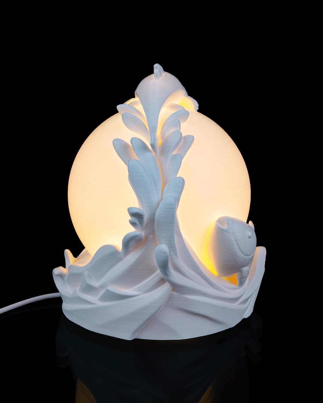 Twin fish sphere lamp lit, side view with power cord