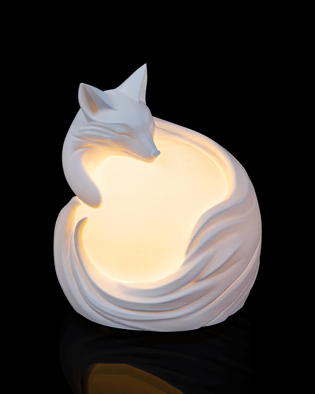 Fox sphere lamp lit, front view with the fox curled around the glowing orb
