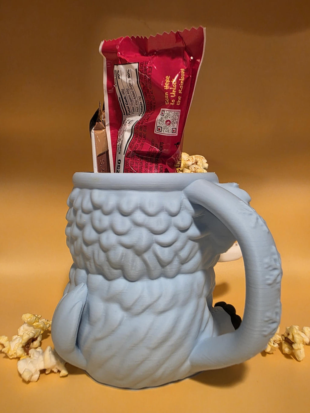 Back of blue-gray Mammuel holding candy, showing the handle