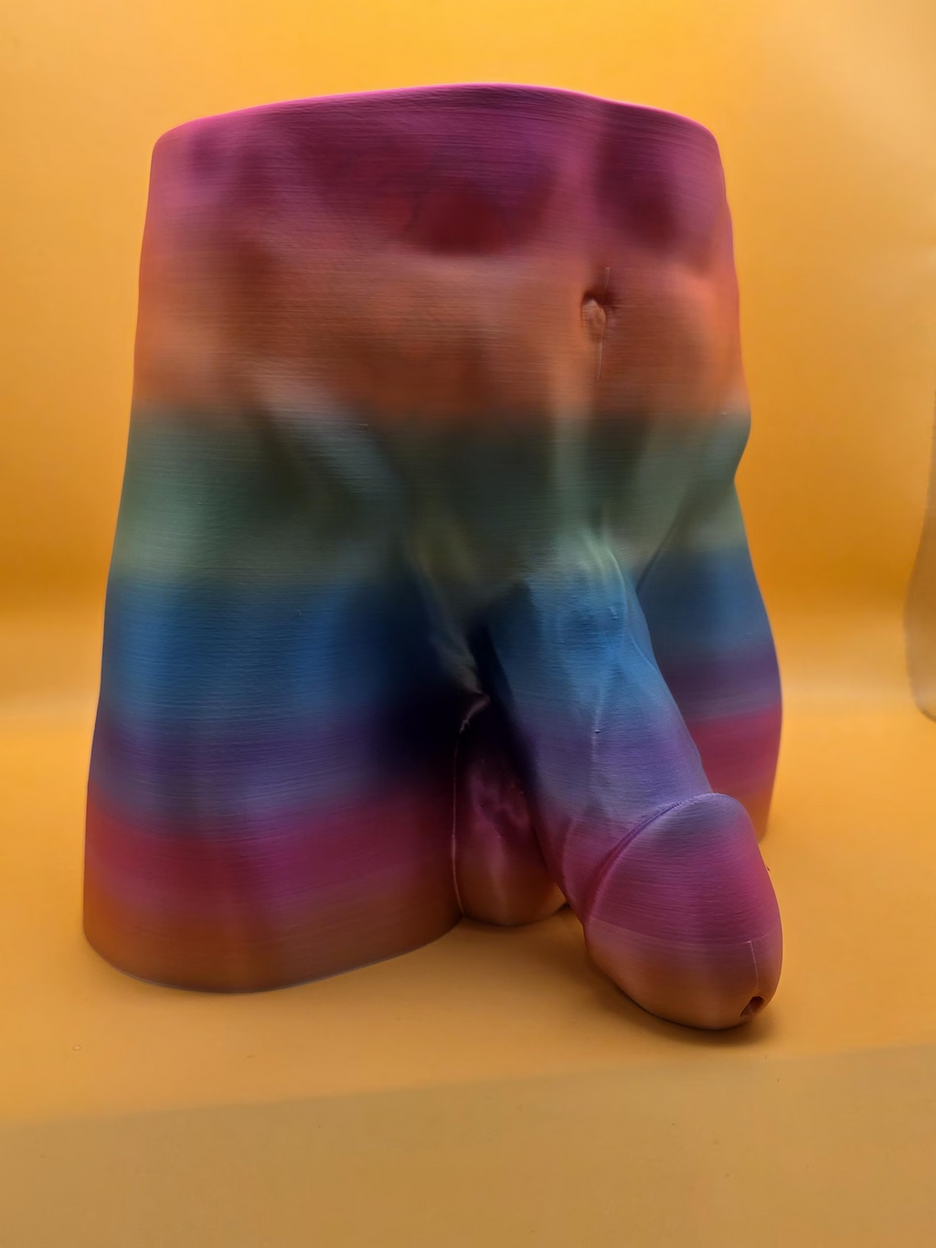 Rainbow color Monster Dong planter showing drainage opening through the member