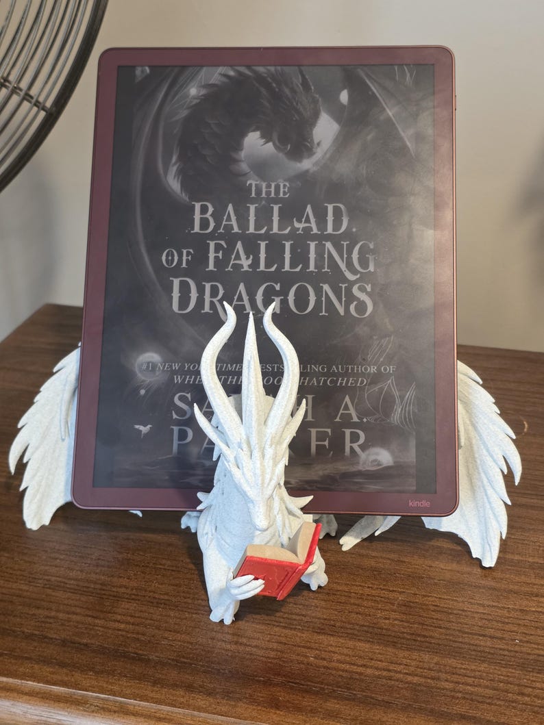 Moonplume holding an e-reader on a wooden table