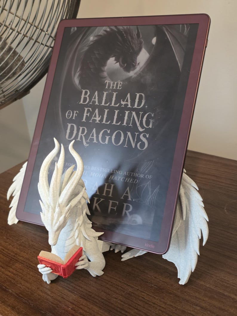 Moonplume dragon stand holding an e-reader, side angle