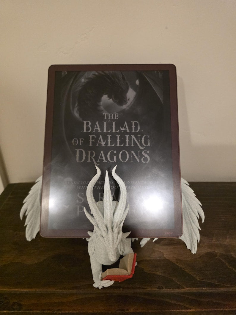 Moonplume dragon stand with an e-reader, red mini book, angled view