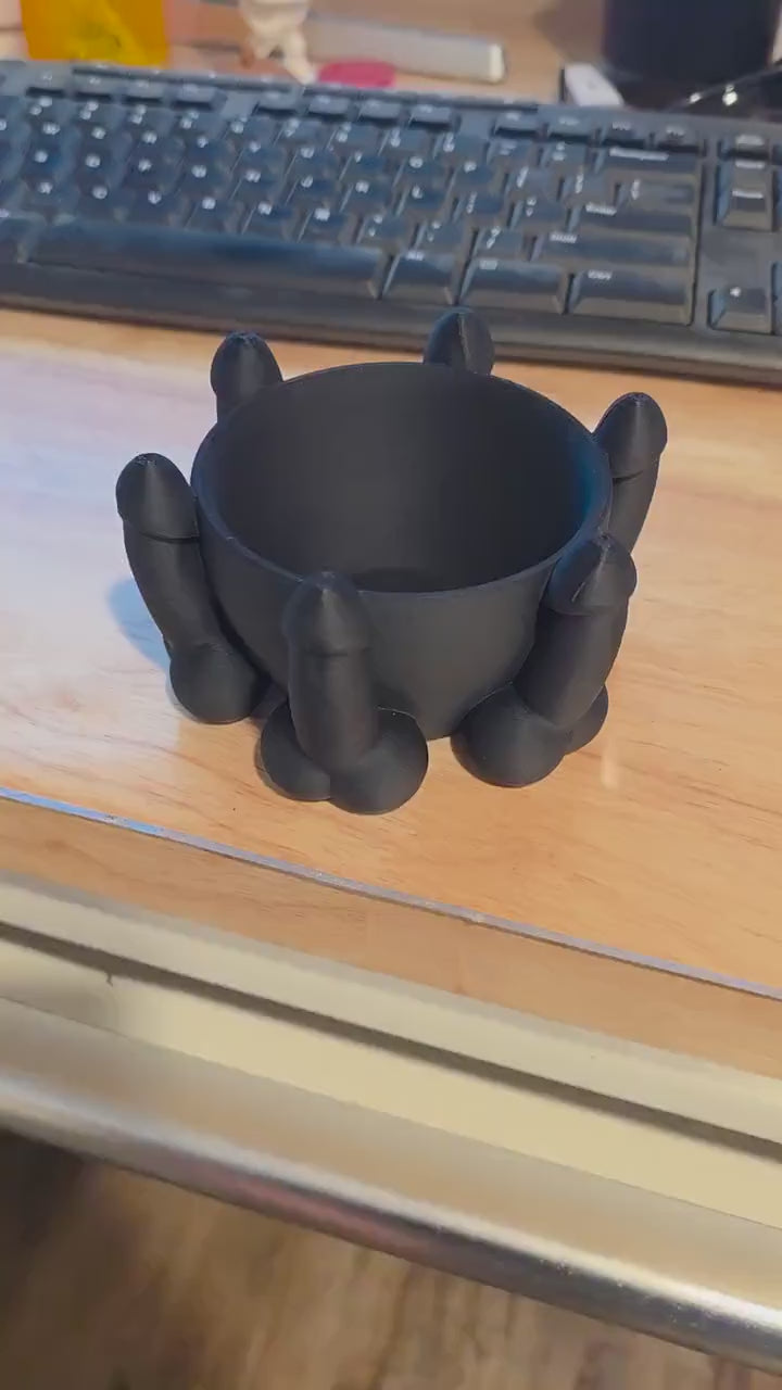 Black penis bowl planter on a desk, showing the drainage holes – product video