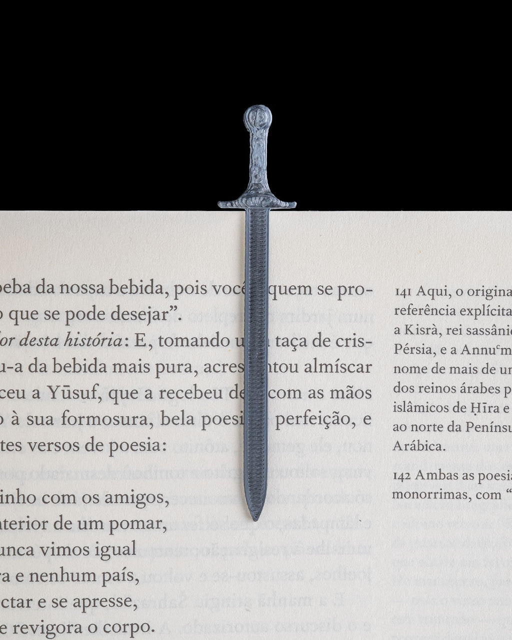 Removable sword bookmark marking a page in an open book