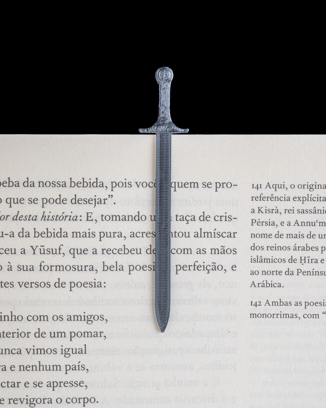 Removable sword bookmark marking a page in an open book